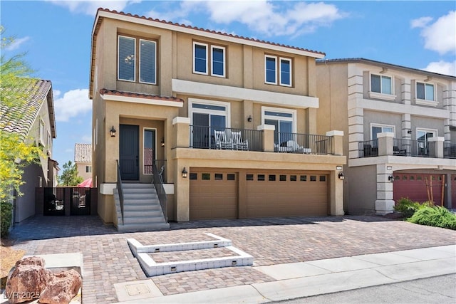 view of property featuring decorative driveway, an attached garage, and stucco siding