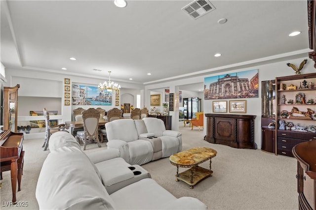 living area featuring a notable chandelier, light carpet, a raised ceiling, recessed lighting, and visible vents