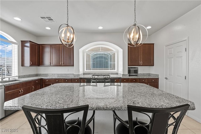 kitchen with an inviting chandelier, hanging light fixtures, a sink, light tile patterned floors, and visible vents