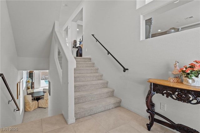 stairs featuring tile patterned floors and baseboards