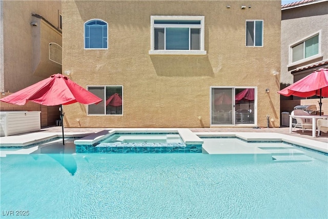 outdoor pool featuring an in ground hot tub and a patio area