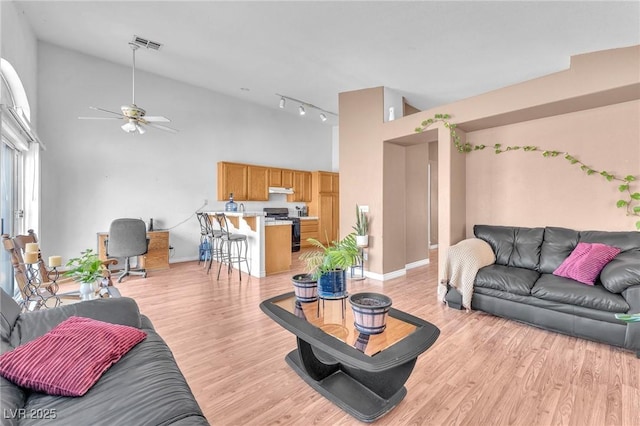2753 Trickling Brook Ct, Las Vegas, NV 89156 - living area with light wood-style flooring, a ceiling fan, high vaulted ceiling, and baseboards