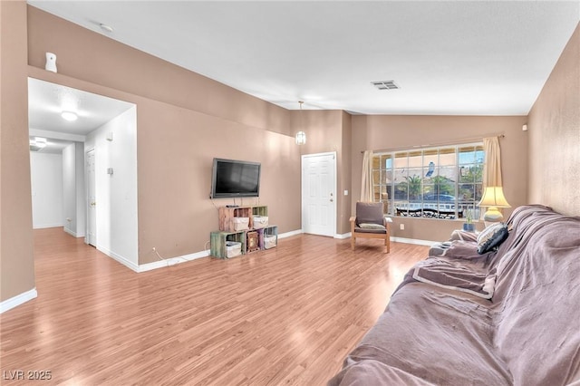 2753 Trickling Brook Ct, Las Vegas, NV 89156 - living room featuring lofted ceiling, light wood-style flooring, and baseboards