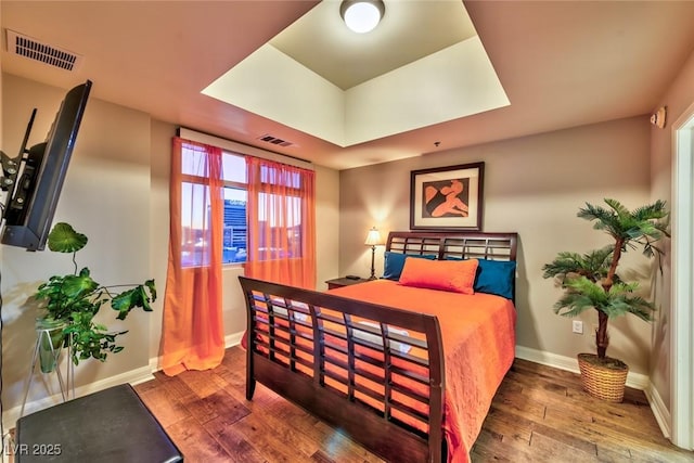 150 Las Vegas Blvd Unit 1606, Las Vegas, NV 89101 - bedroom with baseboards, visible vents, a raised ceiling, and hardwood / wood-style floors