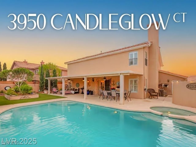 3950 Candleglow Ct, Las Vegas, NV 89147 - pool at dusk with ceiling fan, fence, a pool with connected hot tub, and a patio area