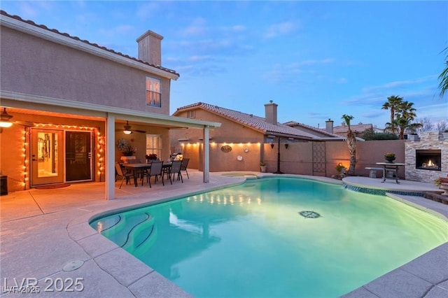 3950 Candleglow Ct, Las Vegas, NV 89147 - view of swimming pool featuring ceiling fan, an outdoor stone fireplace, a fenced backyard, a fenced in pool, and a patio