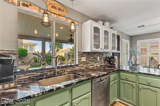 3950 Candleglow Ct, Las Vegas, NV 89147 - kitchen featuring decorative backsplash, visible vents, stainless steel dishwasher, a sink, and green cabinetry