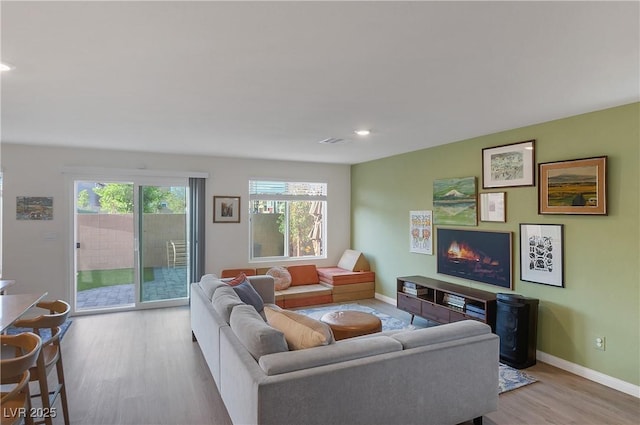 living room with baseboards, recessed lighting, wood finished floors, and visible vents