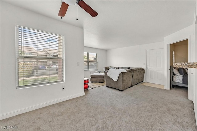 carpeted living room with ceiling fan and baseboards