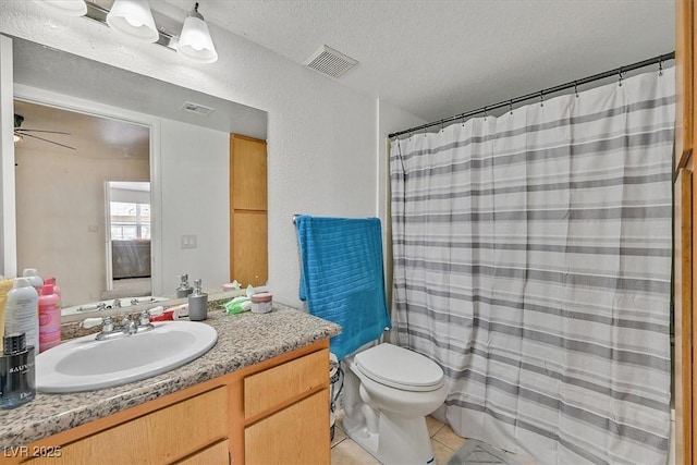 bathroom featuring ceiling fan, a textured ceiling, tile patterned floors, vanity, and toilet