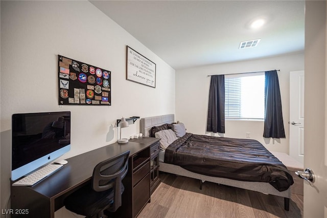 bedroom featuring visible vents and wood finished floors