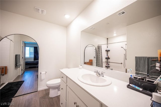 full bathroom featuring visible vents, walk in shower, wood finished floors, and vanity