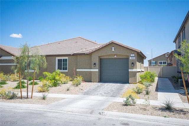 single story home featuring an attached garage, fence, a tile roof, and stucco siding
