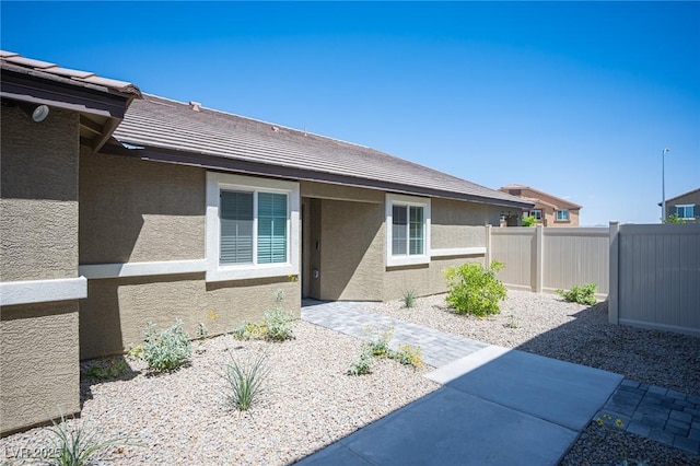 exterior space featuring fence, a patio, and stucco siding