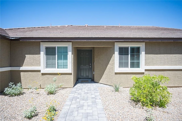 property entrance with a tiled roof and stucco siding