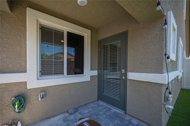 entrance to property with stucco siding