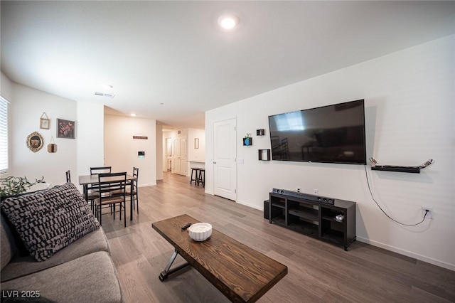 living room featuring baseboards, recessed lighting, wood finished floors, and visible vents