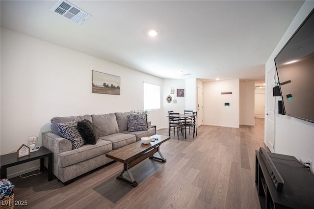 living area featuring visible vents, recessed lighting, light wood-style flooring, and baseboards