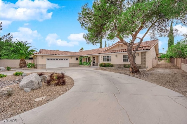 3065 S Torrey Pines Dr, Las Vegas, NV 89146 - mediterranean / spanish-style home featuring a tile roof, stucco siding, a garage, curved driveway, and fence