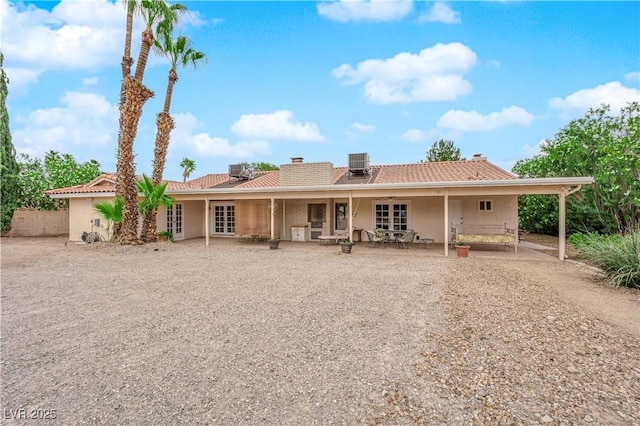 3065 S Torrey Pines Dr, Las Vegas, NV 89146 - back of house with central AC unit, stucco siding, a chimney, and a tiled roof