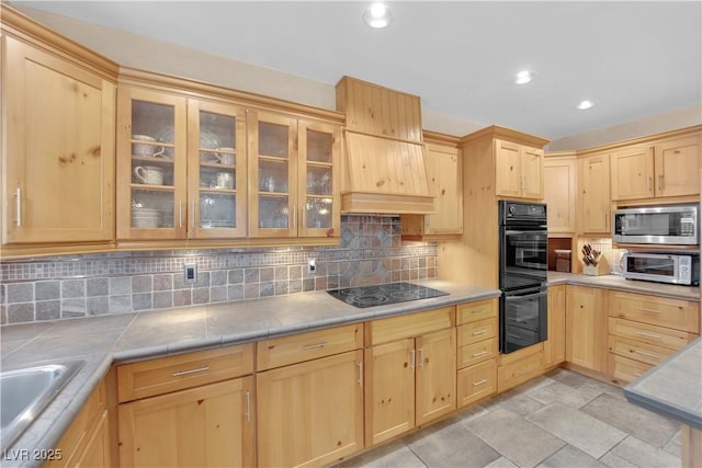 3065 S Torrey Pines Dr, Las Vegas, NV 89146 - kitchen featuring black appliances, light brown cabinetry, tasteful backsplash, glass insert cabinets, and recessed lighting