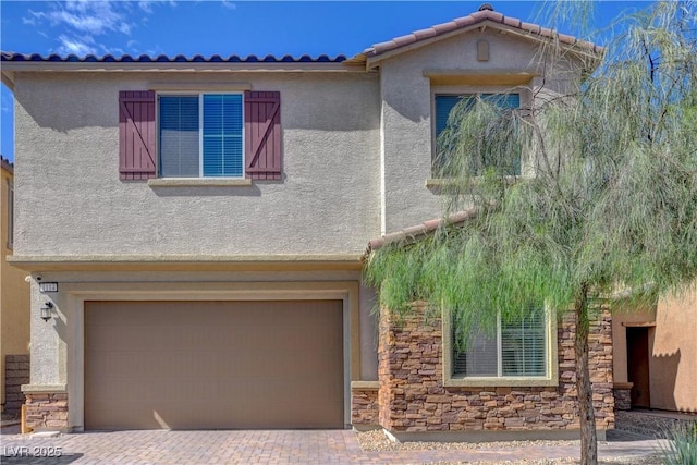 view of front of home featuring a garage, stone siding, decorative driveway, stucco siding, and a tile roof