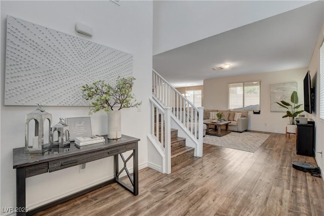 entrance foyer with baseboards, stairs, and wood finished floors