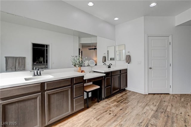 bathroom featuring vanity, baseboards, recessed lighting, and wood finished floors
