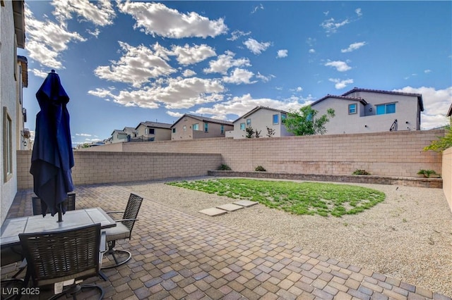 view of patio / terrace with outdoor dining area, a residential view, and a fenced backyard