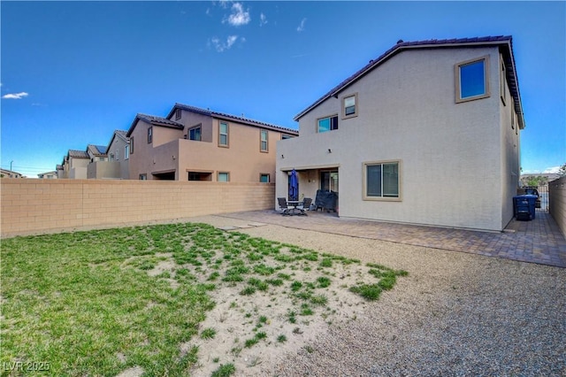 back of property featuring a fenced backyard, a patio, and stucco siding