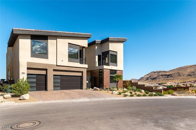 5436 Succulent Rose Dr, Las Vegas, NV 89135 - contemporary home with a garage, a mountain view, stucco siding, and decorative driveway