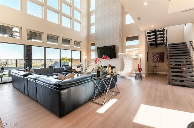 5436 Succulent Rose Dr, Las Vegas, NV 89135 - living area with visible vents, stairs, a towering ceiling, light wood-style floors, and recessed lighting