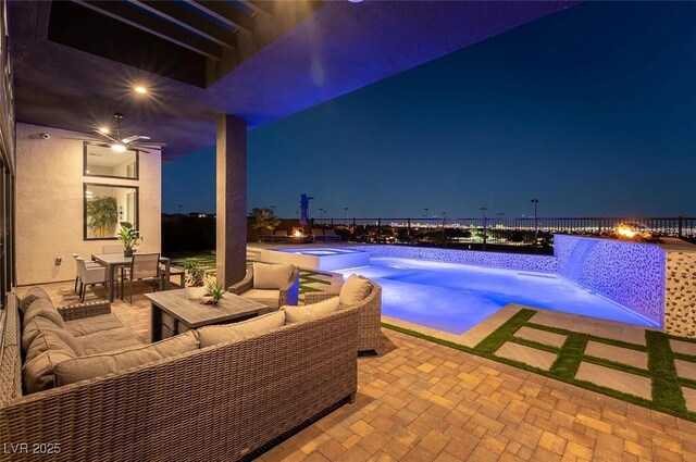 5436 Succulent Rose Dr, Las Vegas, NV 89135 - pool at night with a pool with connected hot tub, an outdoor hangout area, a fenced backyard, outdoor dining area, and a patio area