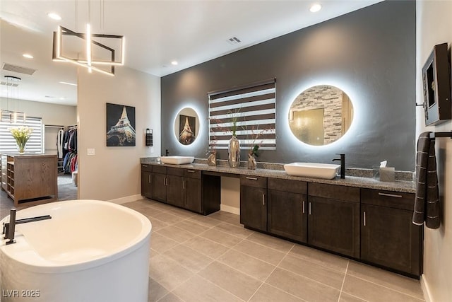 5436 Succulent Rose Dr, Las Vegas, NV 89135 - full bathroom with a freestanding bath, tile patterned flooring, double vanity, baseboards, and visible vents