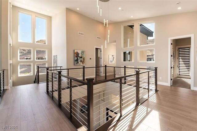 5436 Succulent Rose Dr, Las Vegas, NV 89135 - corridor featuring a high ceiling, an upstairs landing, a healthy amount of sunlight, and visible vents