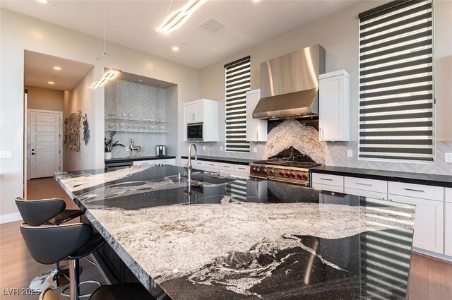 5436 Succulent Rose Dr, Las Vegas, NV 89135 - kitchen featuring wall chimney range hood, backsplash, a large island, a sink, and stainless steel appliances