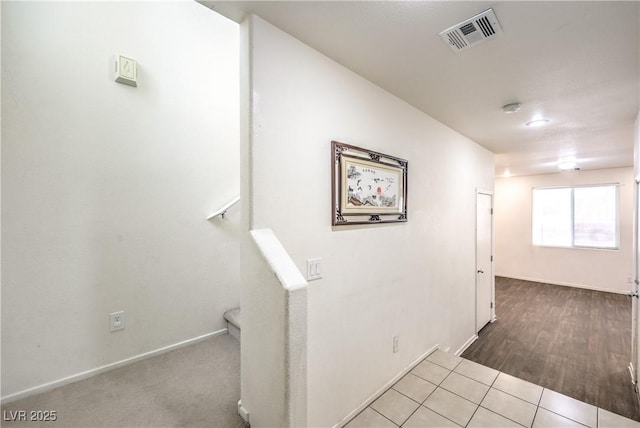 corridor with baseboards and visible vents