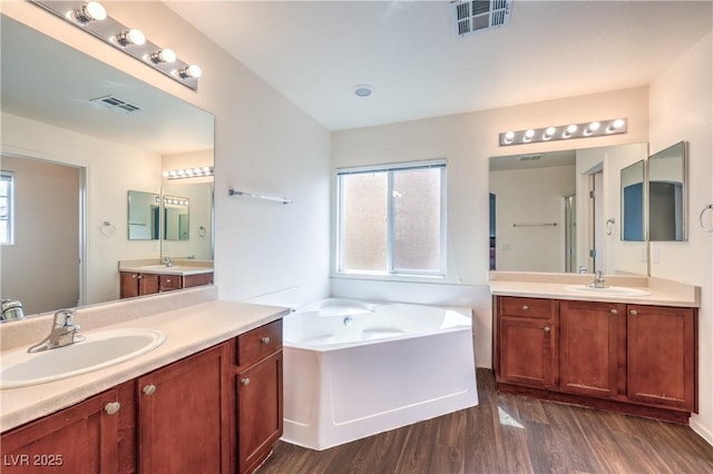bathroom featuring visible vents, a sink, and wood finished floors