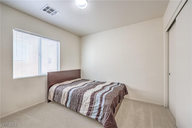 bedroom featuring baseboards, carpet, a closet, and visible vents
