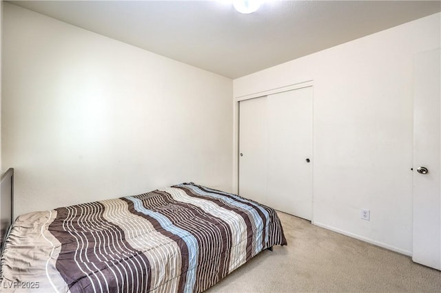 bedroom featuring light colored carpet and a closet