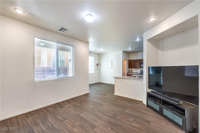 unfurnished living room featuring visible vents, recessed lighting, dark wood finished floors, and baseboards