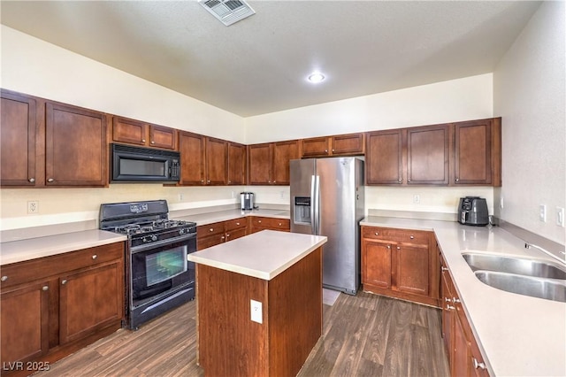 kitchen with a sink, black appliances, dark wood-type flooring, and visible vents