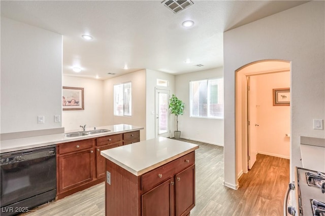 kitchen featuring visible vents, light wood-type flooring, a sink, and dishwasher