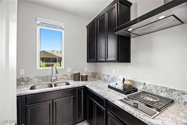 12705 Coastline Shadow St, Las Vegas, NV 89141 - kitchen with a sink, wall chimney range hood, dark cabinets, and light stone counters