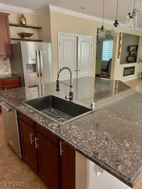 kitchen with a sink, a large island, ornamental molding, and stainless steel appliances