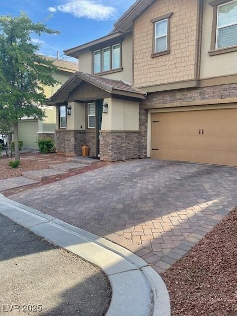 view of front of home featuring stucco siding, an attached garage, decorative driveway, and stone siding