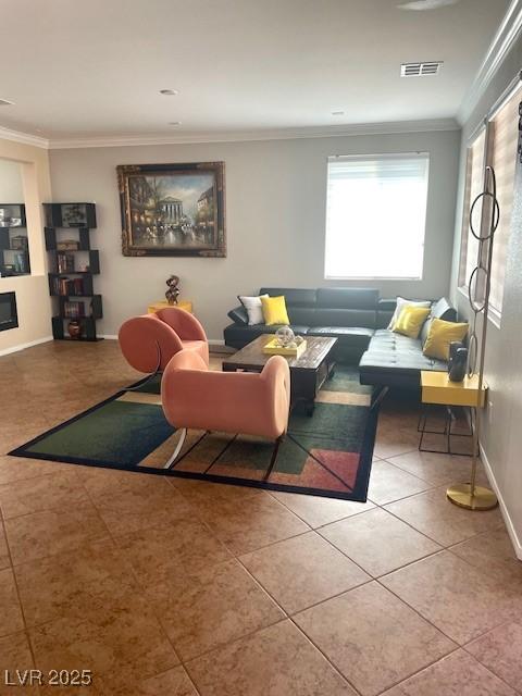 living area with visible vents, baseboards, crown molding, and tile patterned flooring