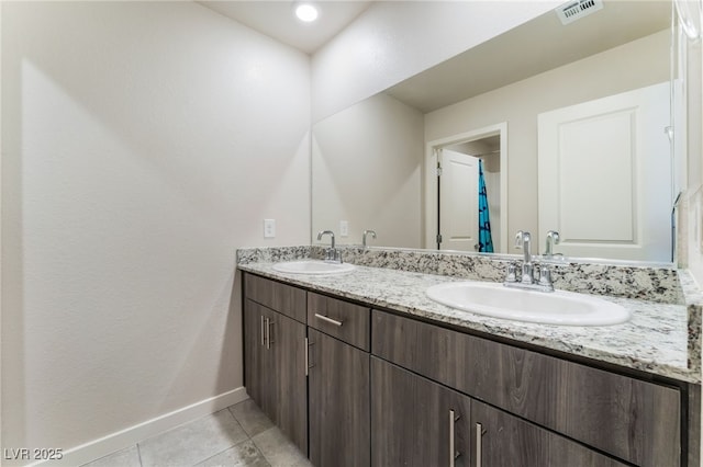 bathroom featuring double vanity, tile patterned floors, visible vents, and a sink