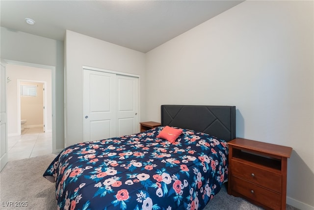 bedroom with carpet floors, baseboards, and a closet