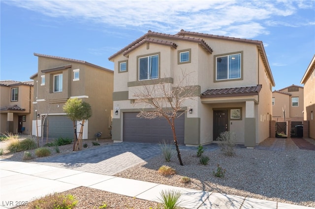 mediterranean / spanish-style house with a garage, a tiled roof, driveway, and stucco siding
